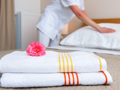 Maid making bed in hotel room